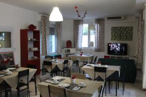 a restaurant with tables and chairs and a television at Hotel Migani in Rimini