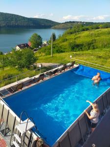 a woman standing in a large swimming pool at Pensiunea Casa Vio in Cinciş