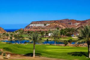 a view of a golf course with palm trees and a lake at Villa Gisel in La Playa de Tauro