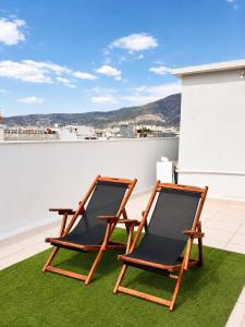 two chairs sitting on the roof of a house at Milla Terrace Apartment Volos in Volos