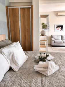 a bedroom with a bed with white sheets and pillows at Milla Terrace Apartment Volos in Volos