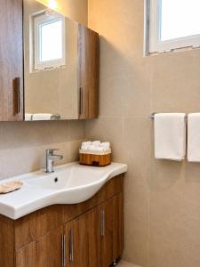 a bathroom with a sink and a mirror and towels at Milla Terrace Apartment Volos in Volos +14 photos