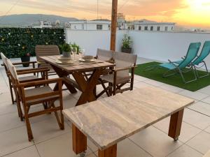a wooden table and chairs on a patio at Milla Terrace Apartment Volos in Volos
