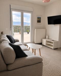 a living room with a couch and a large window at Milla Terrace Apartment Volos in Volos
