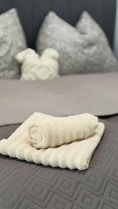 a white towel sitting on top of a bed at Casa Capri Győr in Győr