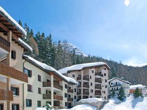 a building covered in snow with a mountain in the background at Bijou Alpina Surlej in Silvaplana