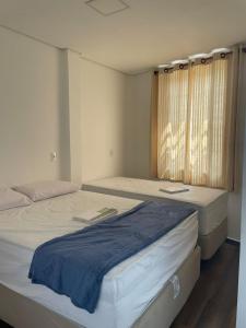 two beds sitting next to each other in a room at Pousada Solar Central in Prados