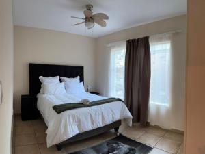 a bedroom with a bed and a ceiling fan at Success Guesthouse in Nelspruit