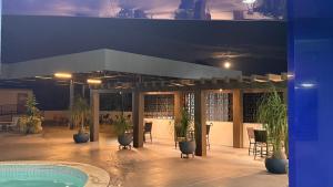 a patio with plants and a swimming pool at night at Hotel Alecrim in Caxias das Aldeias Altas