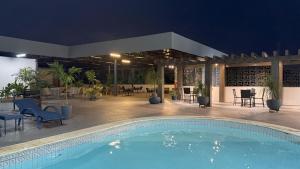 a swimming pool with chairs and a patio at night at Hotel Alecrim in Caxias das Aldeias Altas