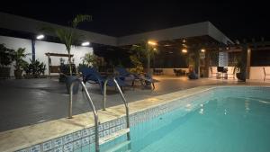 a swimming pool at night with chairs and tables at Hotel Alecrim in Caxias das Aldeias Altas