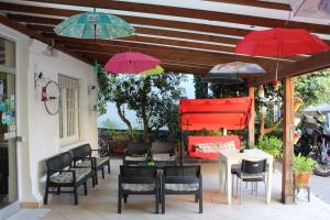 a patio with tables and chairs and umbrellas at Hotel Migani in Rimini