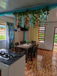 a dining room with a table and a kitchen at La Orquídea Cabañas in Playa Ladrilleros