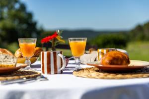 a table with bread and glasses of orange juice at Maison Roque in Sannes