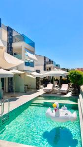 a pool with an inflatable boat in the water next to a building at INTERNI LUXURY LIVING in Nikiti