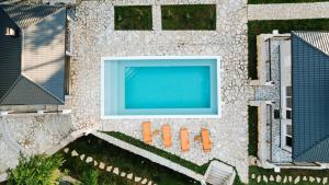 an overhead view of a swimming pool with orange chairs at Villa Vrelo Oasis in Malo Polje