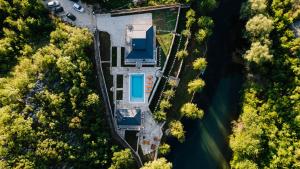an aerial view of a house with a lake at Villa Vrelo Oasis in Malo Polje