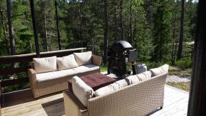two couches and a table on a wooden deck at HagestadHytteutleie Wallhall in Birkenes