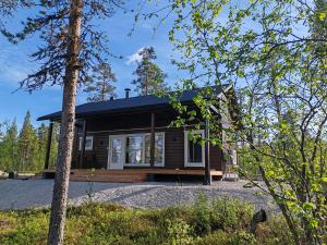 a log cabin with a porch and a house at Villa Goškanjávri in Inari