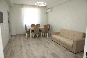 a living room with a couch and a table and chairs at SunRise in Masazır