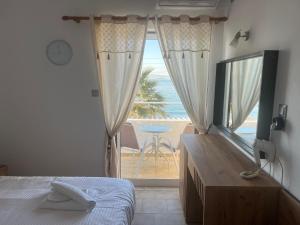 a bedroom with a bed and a view of the ocean at Hotel Beach Amaryllis in Megalochori
