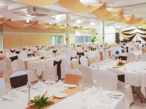 a large banquet hall with white tables and chairs at Novotel Suva Lami Bay in Suva +133 photos