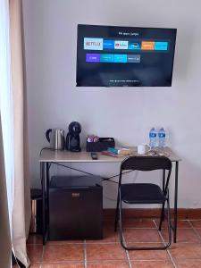 a table with two chairs and a television on a wall at Villa Allyson Boutique Guesthouse in Lloret de Mar