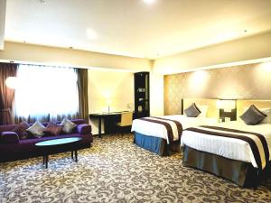 a hotel room with two beds and a couch at Mercure Sapporo in Sapporo