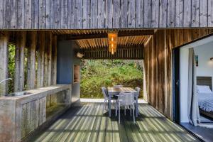 a wooden deck with a table and chairs on a house at GuestReady - Casa do Horizonte in Mosteiros +69 photos