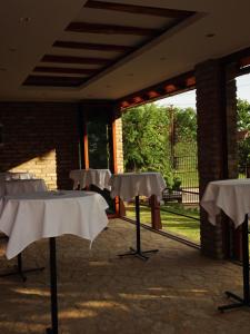 a row of tables with white linen on them at Rodjino imanje in Palić