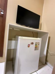 a white refrigerator with a tv on top of it at Refugio Centrico Studio 2 in Ciudad del Este