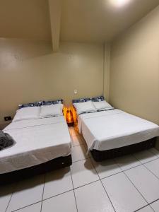 a bedroom with two beds and a lamp in it at Refugio Centrico Studio 2 in Ciudad del Este