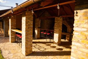 a brick patio with red chairs and a table at Rodjino imanje in Palić