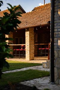 a pavilion with red bar stools under a roof at Rodjino imanje in Palić