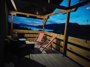 a couple of chairs sitting on a deck at night at Apartman Dunav Plus in Donji Milanovac