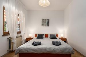 a white bedroom with a large bed with two pillows at Apartman Noemi in Kukci