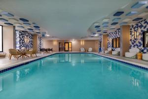a pool in a hotel room with chairs and a table at Hotel Indigo Detroit North - Troy by IHG in Troy
