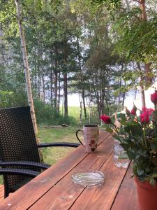 a wooden table with a coffee cup and flowers on it at Tiny House Seeblick in Casel +5 photos
