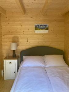 a bed in a room with a wooden wall at Tiny House Seeblick in Casel