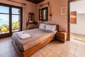a bedroom with a bed with a view of the ocean at Maistros Studios in Damouchari