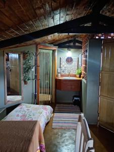 a bedroom with a bed and a bathroom with a sink at Dexa Hospedagem in Ouro Preto +5 photos