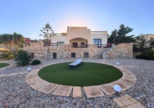 a house with a bench in the middle of a yard at PetraCasa Luxury Villa in Azolimnos Syros