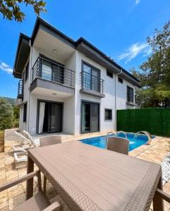 a villa with a swimming pool and a house at Duplex Villa with Private Pool in Akyaka Ataköy in Muğla