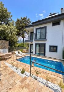 a swimming pool in front of a house at Duplex Villa with Private Pool in Akyaka Ataköy in Muğla