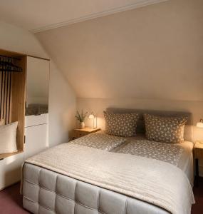 a bedroom with a large white bed with two lamps at Pension Glück in Schleife