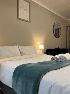 a bedroom with a bed with two towels on it at Dainfern Cozy Loft in Fourways +2 photos