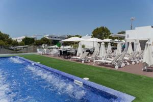 a swimming pool with chairs and a table and umbrella at hotel apartamento es Talaial in Cala d´Or +6 photos