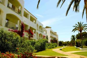 a building with flowers and plants in front of it at hotel apartamento es Talaial in Cala d´Or
