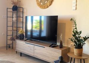 a flat screen tv sitting on top of a wooden entertainment center at PetraCasa Luxury Villa in Azolimnos Syros