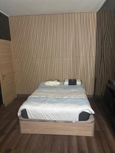 a bed in a room with a striped wall at Appart 4 personnes in Lille